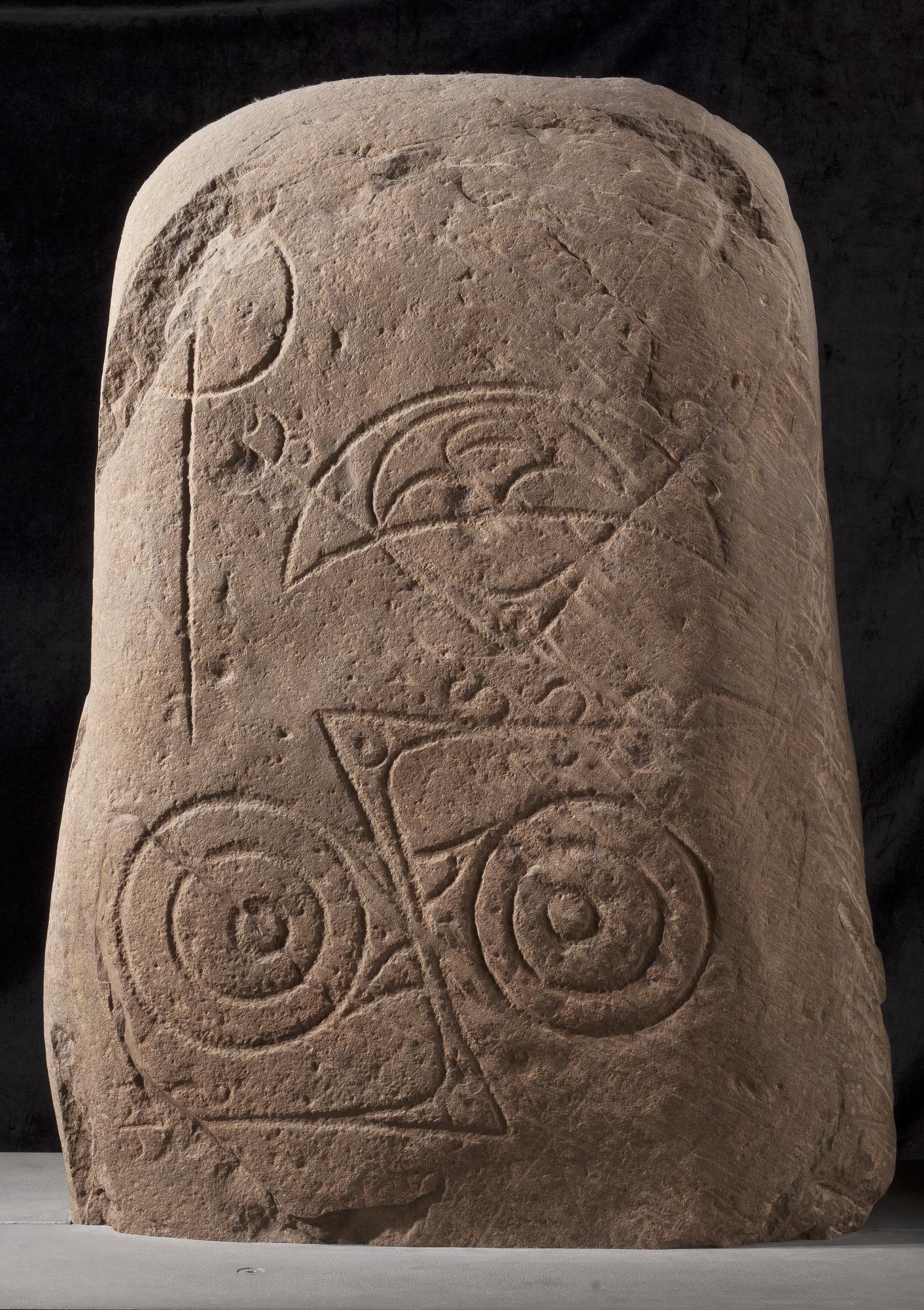 Photograph of a Class I Pictish symbol stone from Invereen on the River Findhorn. It has two incised symbols: a crescent and v-rod and a double disc and z-rod.